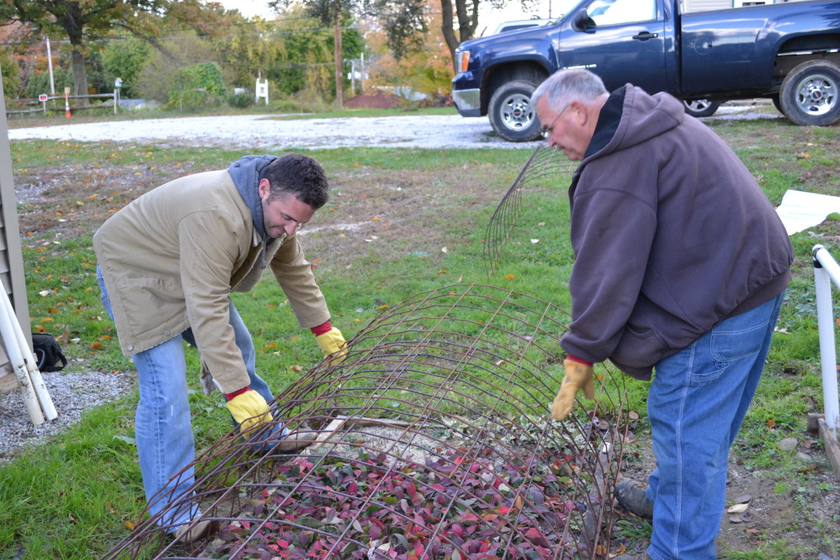 Mike and Duston McGroarty covering plants for the winter.