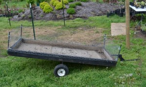 Homemade garden cart for moving small nursery plants.